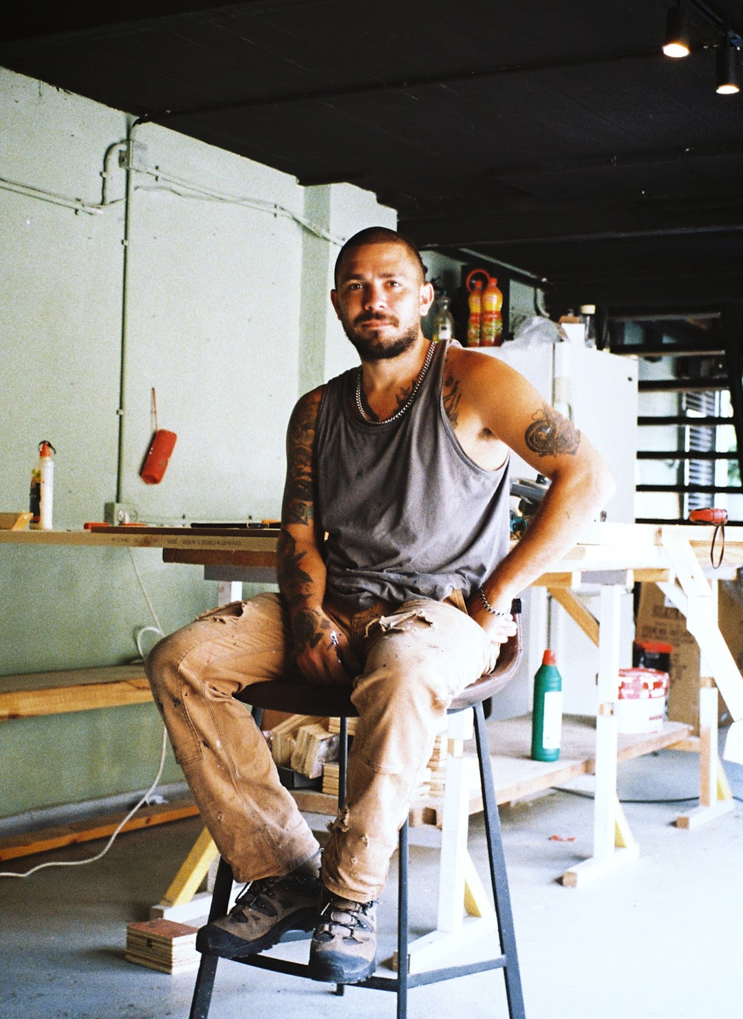 Douglas Williams seated on a stool in his art studio